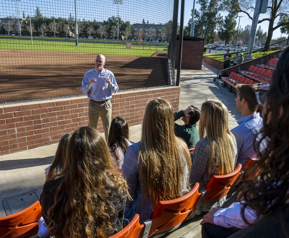 students having a lecture by the baseball fields
